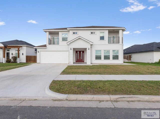 view of front of house with a balcony, a garage, and a front lawn