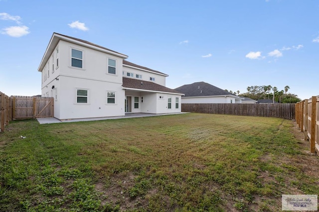 back of property with a patio area and a yard