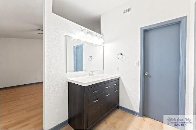 bathroom featuring vanity, ceiling fan, and wood-type flooring