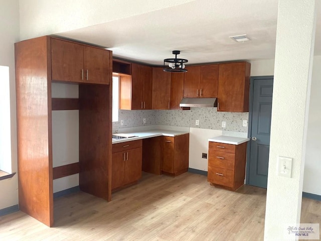 kitchen with tasteful backsplash and light wood-type flooring