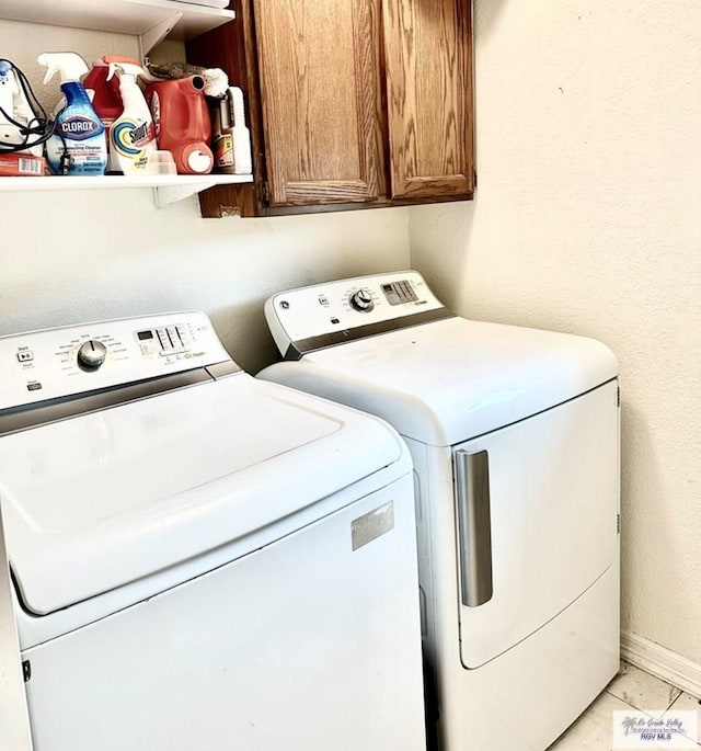 laundry room with cabinets, independent washer and dryer, and light tile patterned floors