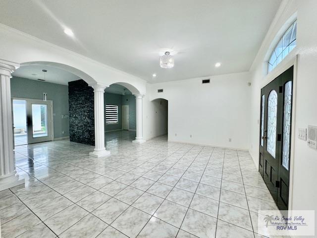 tiled spare room with a chandelier, french doors, and ornate columns