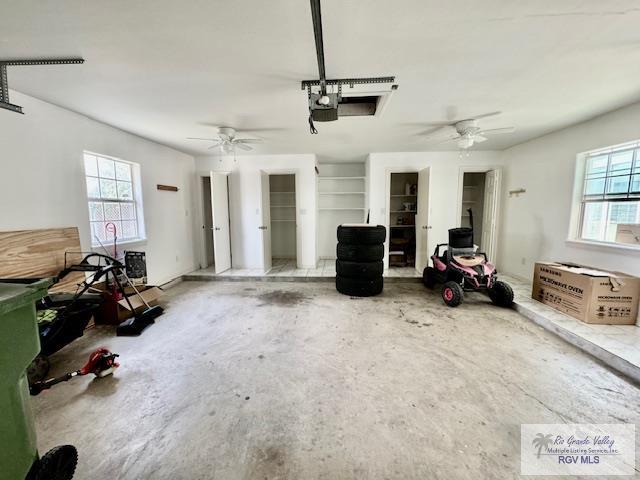 garage with a garage door opener and ceiling fan