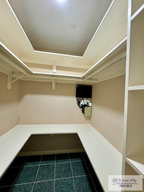 spacious closet with dark tile patterned floors