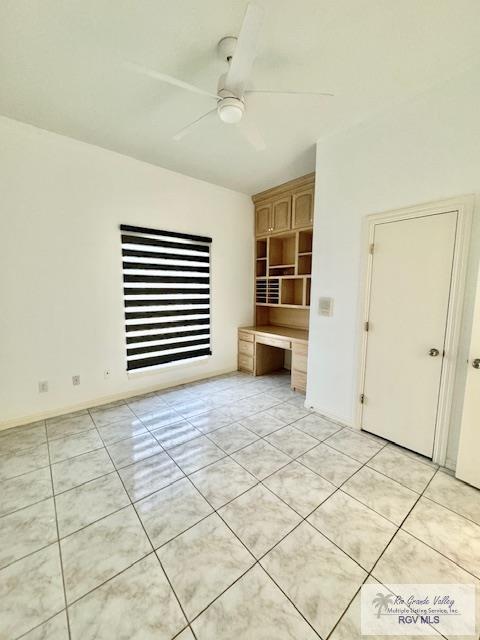 interior space with ceiling fan and built in desk