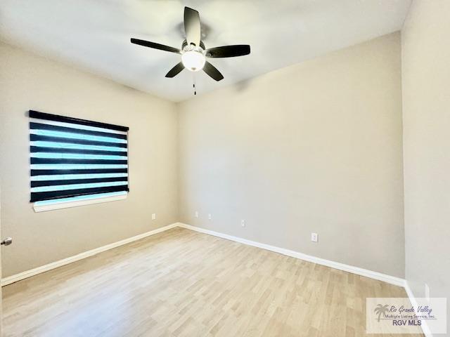 empty room with ceiling fan and light hardwood / wood-style floors