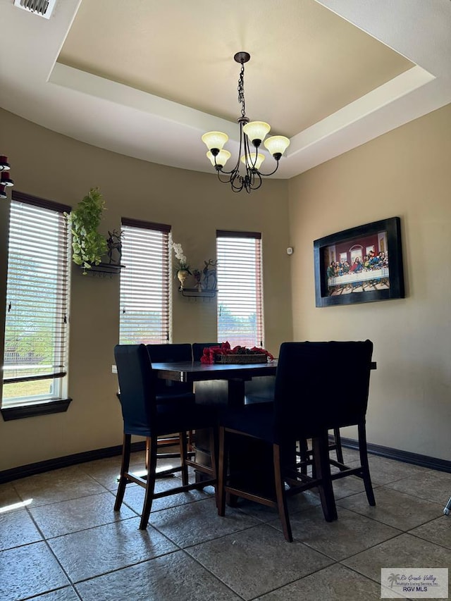 2909 Mi Cielo Dr, Weslaco, TX 78599 - dining space featuring a tray ceiling, baseboards, and a chandelier