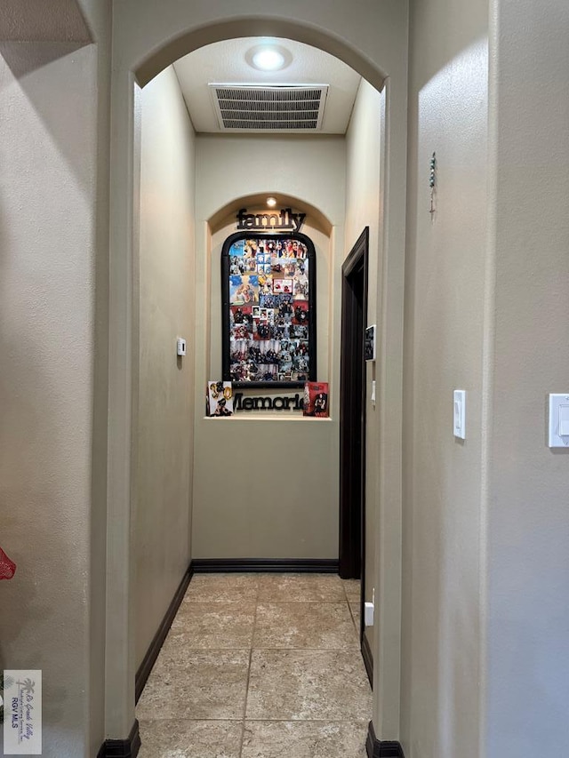 2909 Mi Cielo Dr, Weslaco, TX 78599 - hall featuring arched walkways, baseboards, and light stone finish flooring
