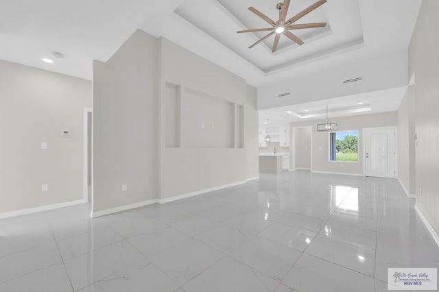 4698 Kalinga Ln, Brownsville, TX 78521 - unfurnished living room with a ceiling fan, a tray ceiling, marble finish floors, baseboards, and recessed lighting