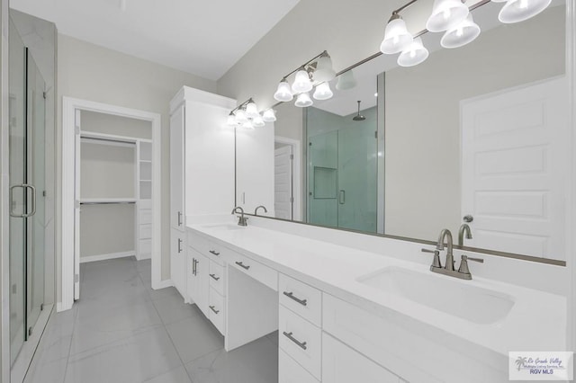 4698 Kalinga Ln, Brownsville, TX 78521 - full bathroom with a stall shower, marble finish floors, double vanity, a chandelier, and a spacious closet