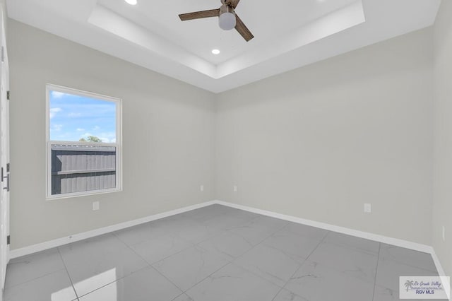 4698 Kalinga Ln, Brownsville, TX 78521 - spare room with marble finish floors, baseboards, ceiling fan, recessed lighting, and a tray ceiling