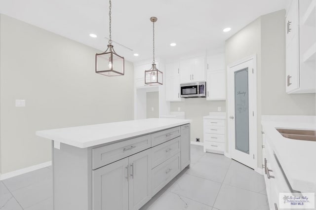 4698 Kalinga Ln, Brownsville, TX 78521 - kitchen with stainless steel microwave, white cabinetry, hanging light fixtures, recessed lighting, and open shelves