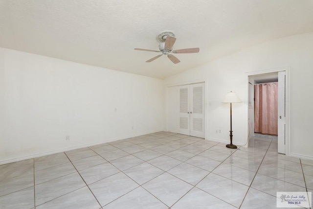 empty room with ceiling fan and vaulted ceiling