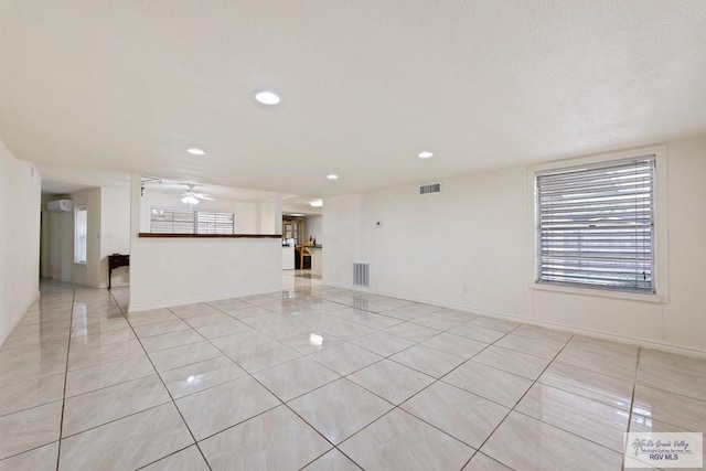 interior space with ceiling fan and a wall mounted AC