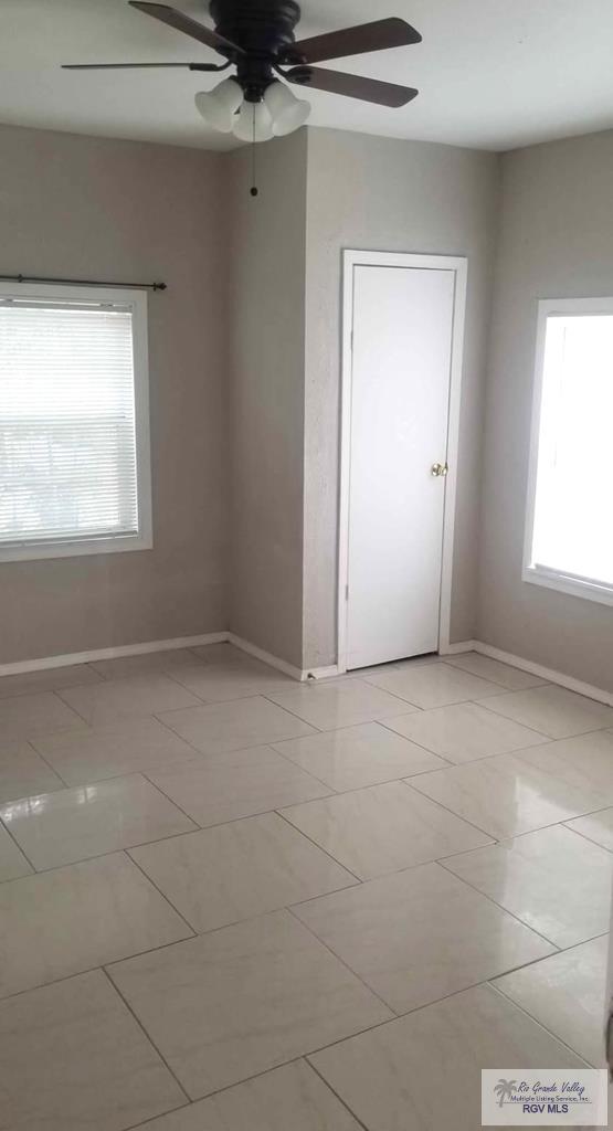 spare room featuring light tile patterned flooring and ceiling fan