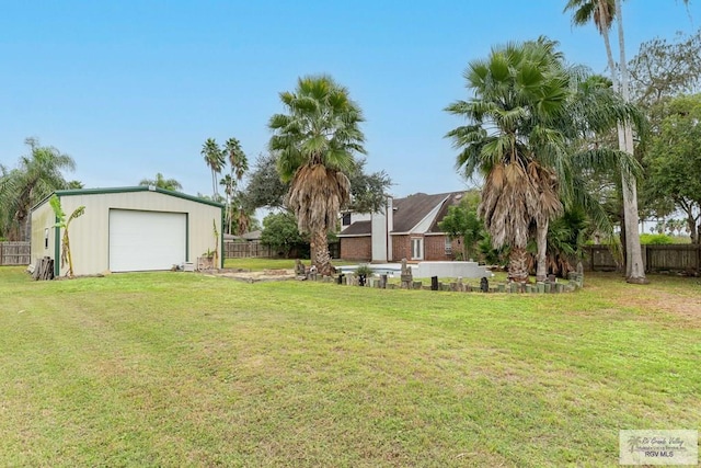 view of yard featuring a garage and an outbuilding