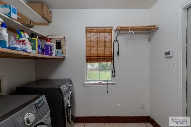 laundry room with washer and dryer and light tile patterned flooring