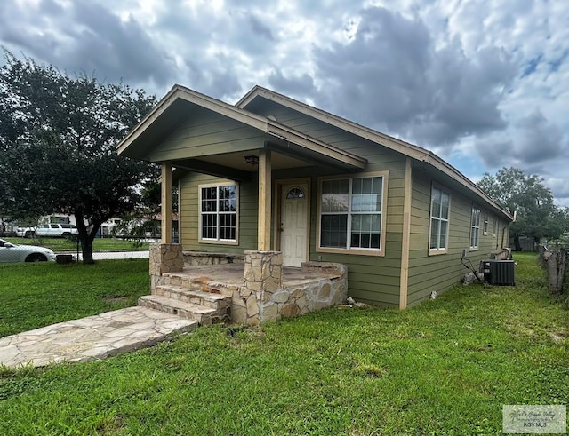 view of front of property featuring a front yard, a porch, and cooling unit