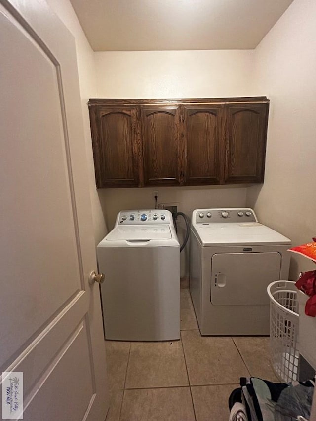 laundry room featuring cabinets, washing machine and dryer, and light tile patterned flooring