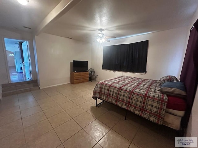 bedroom with ceiling fan, light tile patterned floors, and white fridge