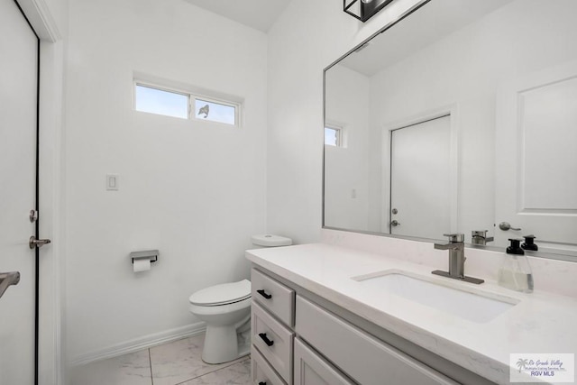 half bath featuring vanity, marble finish floor, baseboards, and toilet