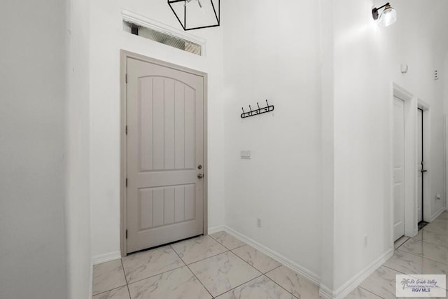 foyer featuring baseboards and marble finish floor