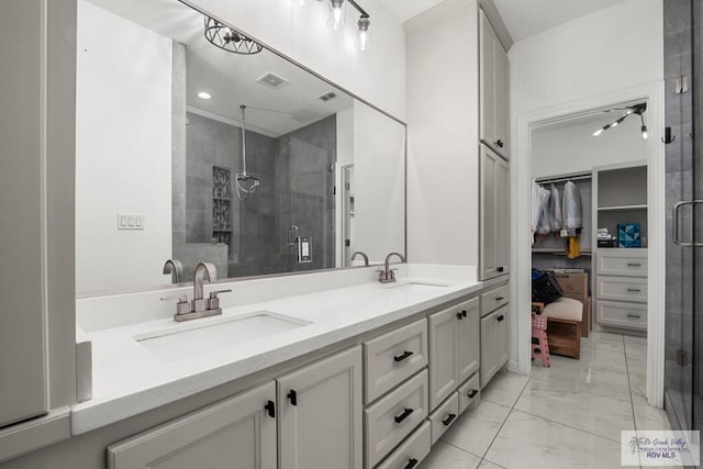 full bathroom with double vanity, a sink, marble finish floor, and a stall shower
