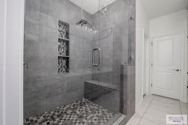 bathroom featuring marble finish floor and a shower stall