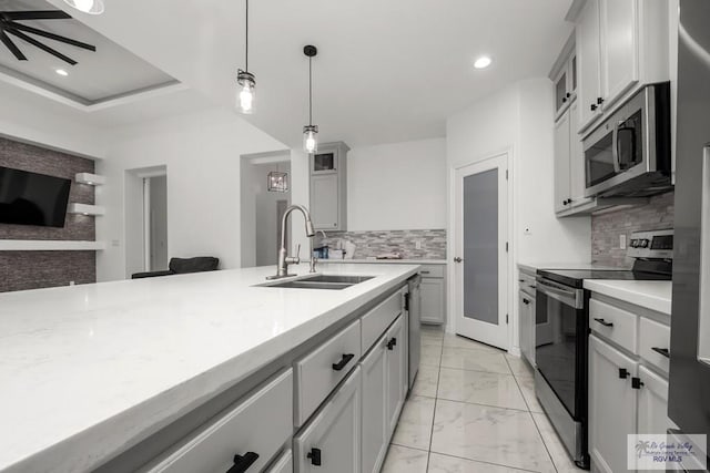 kitchen featuring appliances with stainless steel finishes, tasteful backsplash, a sink, light countertops, and marble finish floor