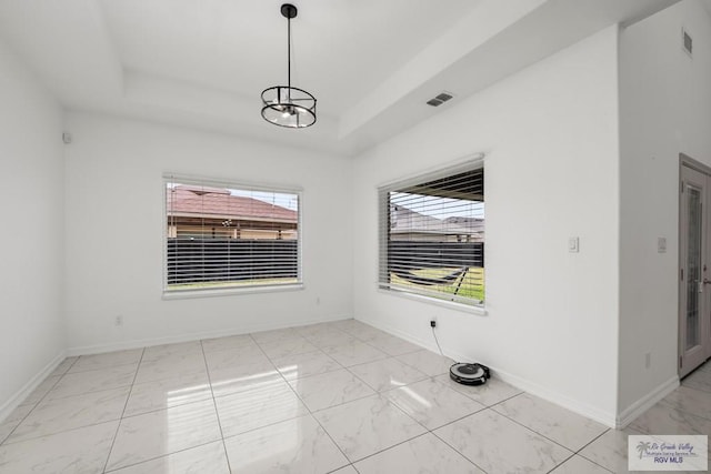 unfurnished dining area featuring a raised ceiling, visible vents, baseboards, and marble finish floor