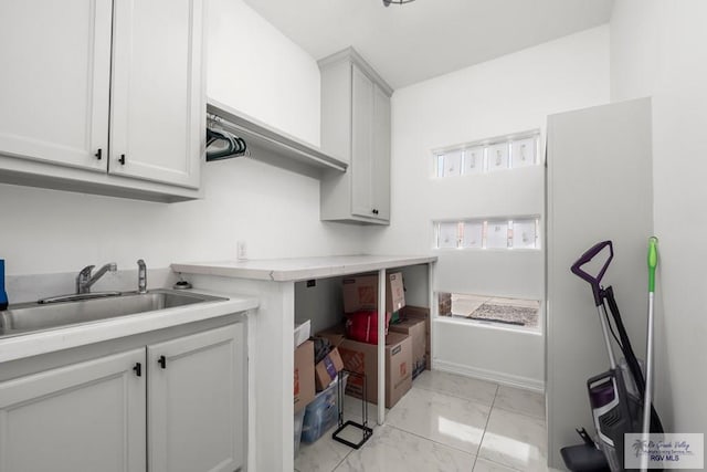 laundry area featuring a sink and marble finish floor