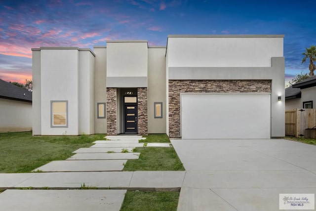 view of front of house featuring a garage, fence, concrete driveway, and stucco siding