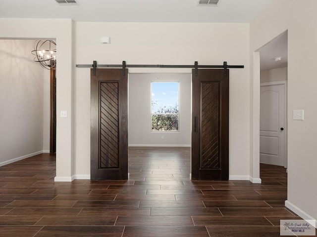 23756 Richmond Cir, Harlingen, TX 78552 - unfurnished bedroom with a barn door, dark wood-style flooring, and a chandelier