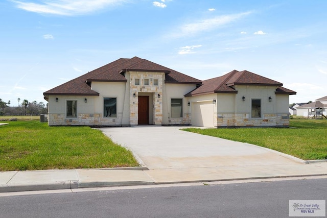 1902 Thacker Ln, Harlingen, TX 78552 - prairie-style home with stone siding, a garage, a front yard, driveway, and stucco siding