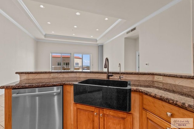 201 W Capricorn Dr, South Padre Island, TX 78597 - kitchen with stainless steel dishwasher, a sink, brown cabinets, a tray ceiling, and recessed lighting