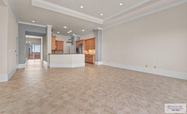 201 W Capricorn Dr, South Padre Island, TX 78597 - unfurnished living room featuring a chandelier, ornamental molding, recessed lighting, a raised ceiling, and baseboards