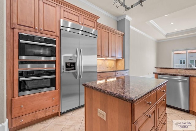 201 W Capricorn Dr, South Padre Island, TX 78597 - kitchen with appliances with stainless steel finishes, light tile patterned flooring, a kitchen island, ornamental molding, and dark stone countertops