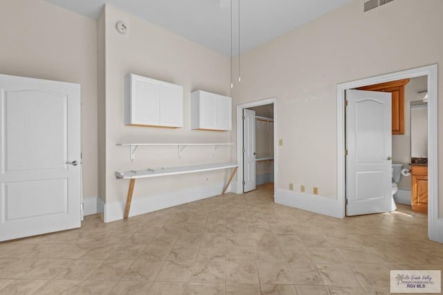 201 W Capricorn Dr, South Padre Island, TX 78597 - unfurnished bedroom with baseboards, a spacious closet, and light tile patterned flooring