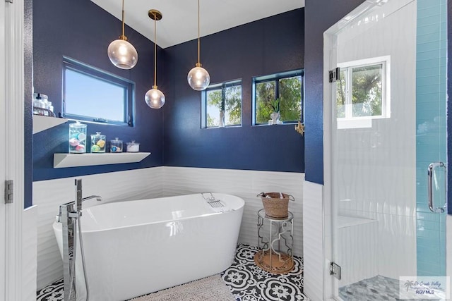 bathroom with separate shower and tub and tile walls