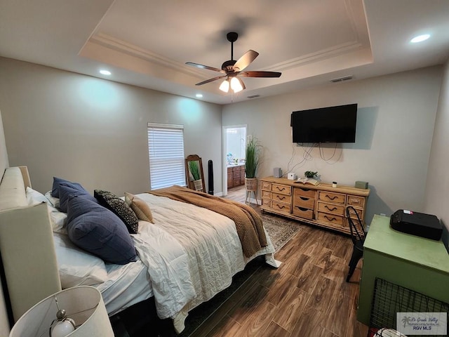 bedroom featuring ceiling fan, ornamental molding, dark hardwood / wood-style flooring, and a raised ceiling