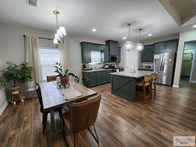 dining space with dark wood-type flooring and a wealth of natural light