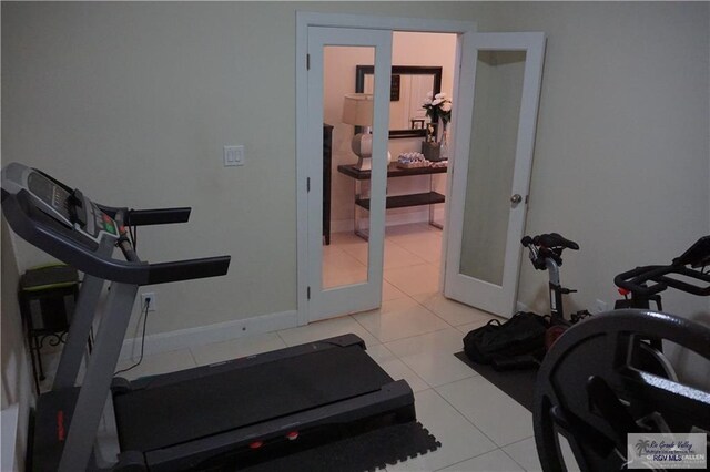 exercise room featuring light tile patterned floors and french doors