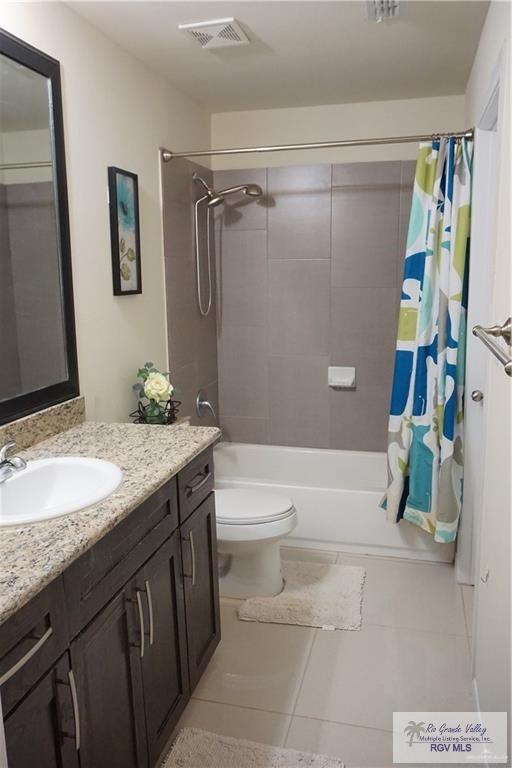 full bathroom with tile patterned floors, vanity, shower / bath combination with curtain, and toilet