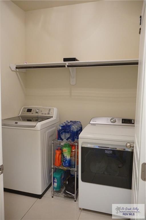 washroom with washer and clothes dryer and light tile patterned floors