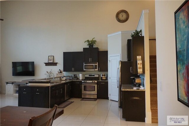 kitchen featuring light tile patterned flooring, sink, and appliances with stainless steel finishes