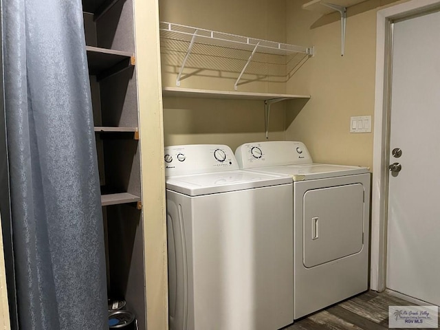 clothes washing area with dark hardwood / wood-style floors and washing machine and clothes dryer