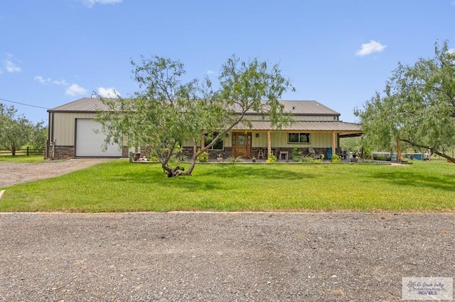 25096 Rabb Rd, La Feria, TX 78559 - view of front facade with dirt driveway, a garage, a porch, and a front lawn
