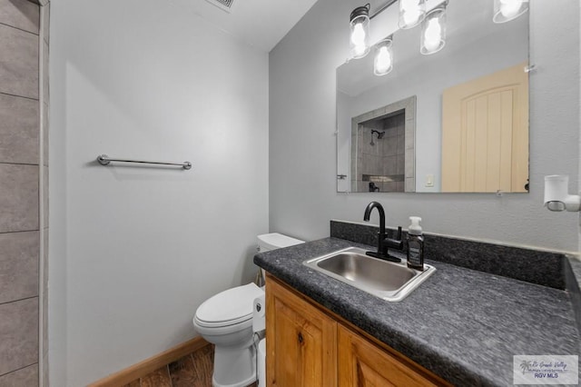 25096 Rabb Rd, La Feria, TX 78559 - bathroom featuring vanity, a tile shower, and wood finished floors