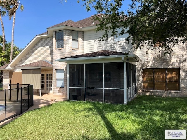 901 Morelos Ave, Rancho Viejo, TX 78575 - rear view of property featuring a sunroom, a lawn, a patio, and brick siding
