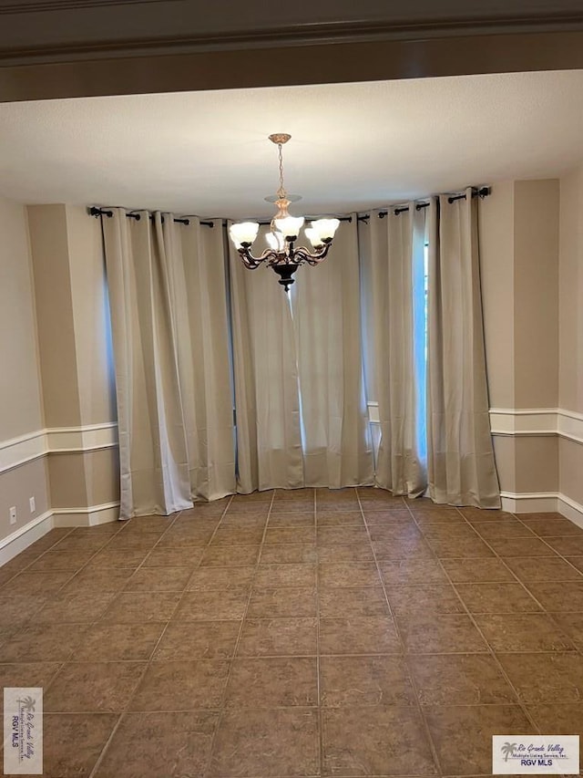 901 Morelos Ave, Rancho Viejo, TX 78575 - tiled empty room with a chandelier and baseboards